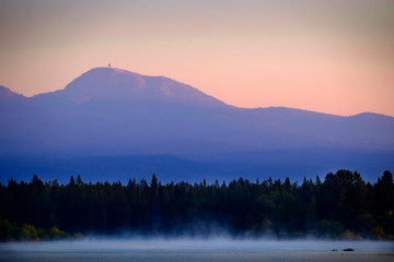Sunrise Sunset on Lake with Mist Rising from Water Pine Trees and Mountains in Background Mt Sawtell