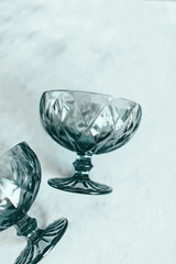 Empty dark glass plate for dessert beautiful glasses for desserts and cocktails on a light background Copy space Selective focus