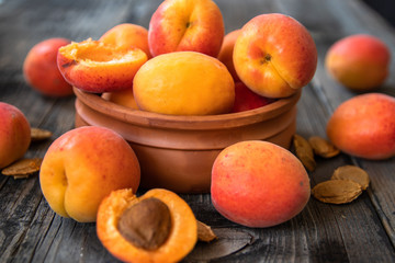 Fototapeta na wymiar Fresh organic apricots in a clay bowl on old wooden table