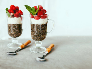 dessert made from healthy foods Chia, coconut and raspberry dessert in a beautiful glass on a light...