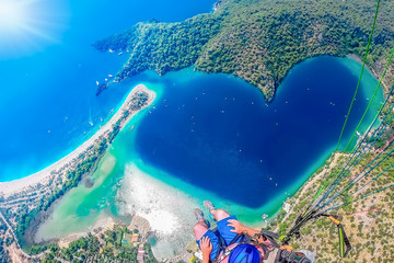 Extreme sport. Landscape . Paragliding in the sky. Paraglider tandem flying over the sea with blue...