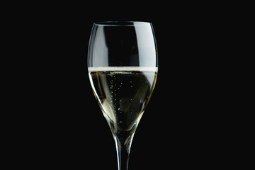 Glass of sparkling wine or Champagne on black background