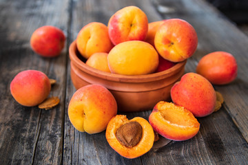 Naklejka na ściany i meble Fresh organic apricots in a clay bowl on old wooden table