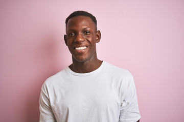 African american man wearing white t-shirt standing over isolated pink background with a happy face standing and smiling with a confident smile showing teeth
