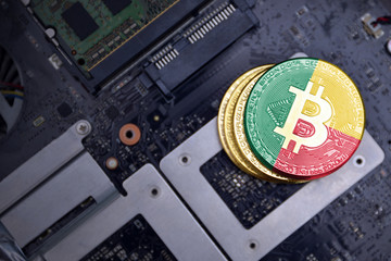 golden bitcoins with flag of benin on a computer electronic circuit board. bitcoin mining concept.