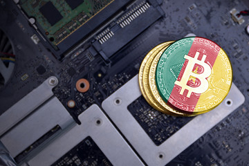 golden bitcoins with flag of cameroon on a computer electronic circuit board. bitcoin mining...