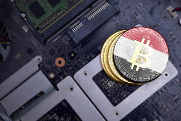 golden bitcoins with flag of egypt on a computer electronic circuit board. bitcoin mining concept.