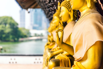 Golden Buddha statues in the courtyard of the temple Gangaramaya, Colombo, Sri Lanka. With selective focus.