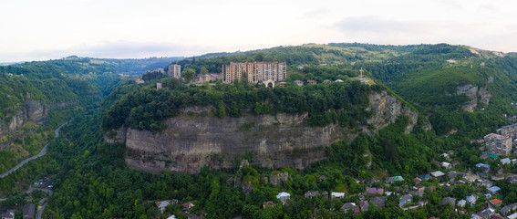 Old rusty and functioning ropeway or cable car cabins in Chiatura. Panorama of the city district...