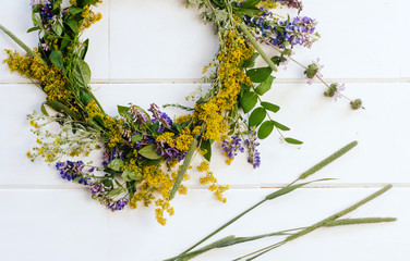  wreath of wild flowers. yellow and purple wildflowers on a white wooden background