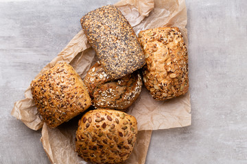 Assortment of baked bread on wooden table background.