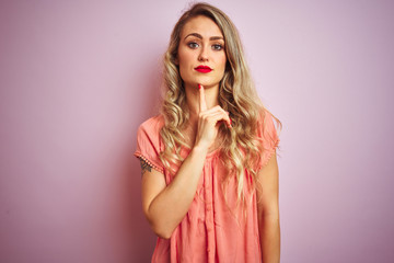 Young beautiful woman wearing t-shirt standing over pink isolated background Thinking concentrated about doubt with finger on chin and looking up wondering