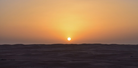 Anochecer en el desierto con el sol a punto de desaparecer