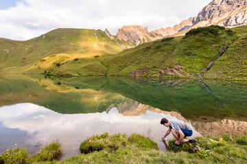Schrecksee, Allg‰u, Bavaria, Germany: A male hiker refilling  a water bottle with the clear water of the Schrecksee, a small alpine lake in the Allg‰u Alps.