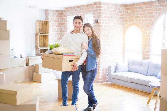 Beautiful young asian couple looking happy and smiling excited moving to a new home