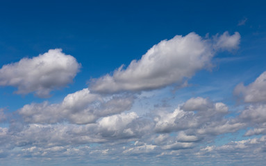 Cumulus fluffy clouds in the blue sky. Harbingers of rain.