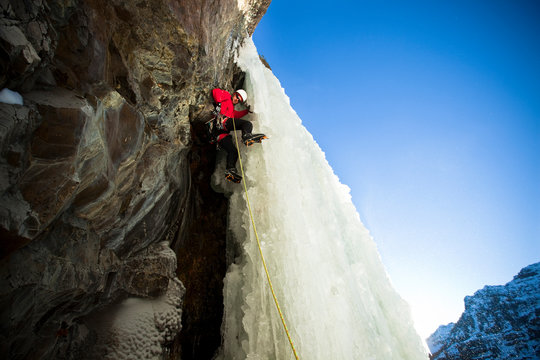 Tim Stabio climbs out of a cave onto The Scepter WI5 in Hyalite Canyon.    