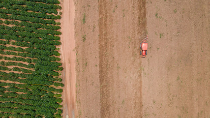 Top view of agricultural tractor vehicles working at field