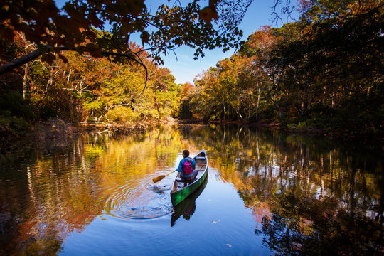 Bekah Herndon canoeing on the still waters of a freshwater pond along the Discovery Trail during a sunny autumn afternoon at the Nags Head Woods Preserve.