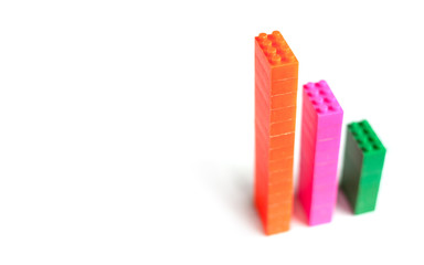 Plastic toy blocks, designer of children's toys as financial graph on white background. Graph with three 3 steps. Growing chart. Multi-colored blocks.