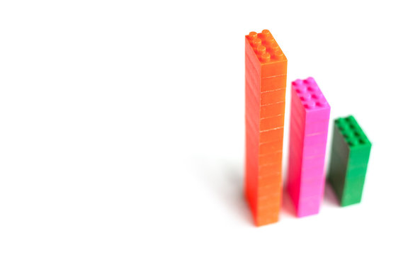 Plastic toy blocks, designer of children's toys as financial graph on white background. Graph with three 3 steps. Growing chart. Multi-colored blocks.