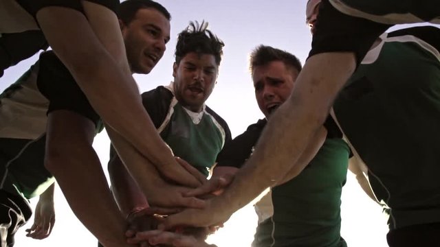 Rugby team putting their hands together before the match. Rugby players cheering and ready to win.