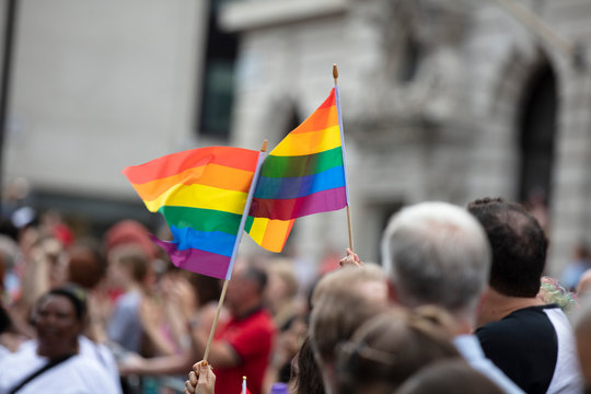 Spectators waves a gay rainbow flag at an LGBT gay pride community event
