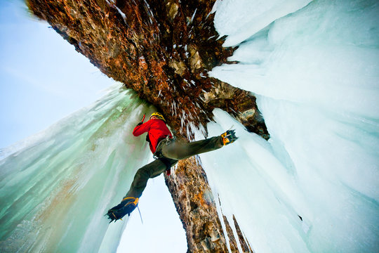 Man ice climbing on rock