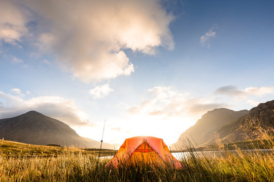 Llyn Idwal (lake), Snowdonia National Park, Bangor, Wales, United Kingdom: A tent at the lake in the early morning light just after sunrise.