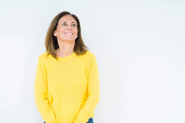 Obraz premium Beautiful middle age woman wearing yellow sweater over isolated background looking away to side with smile on face, natural expression. Laughing confident.