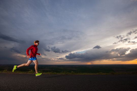 Distance runner  on a evening run on the scenic road up Steptoe Butte State Park in eastern Washington state at sunset.