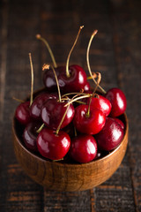 Bowl Full of Dark Red Cherries with Stems on a White Background