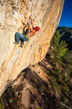 A man on Telemaster (8a/5.13b) at the Raco de les Espadelles sector at Margalef, Spain at sunset.