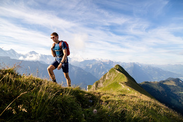 Hardergrat (ridge) hike above Lake Brienz, Canton of Bern, Switzerland: Hiking the Hardergrat from Interlaken town to the Brienzer Rothorn, which is an extreme hike covering about 27 kilomters and 3000 vertical meters. // A male hiker on the ridge that is Hardergrat.