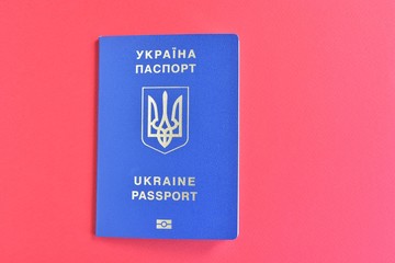 Biomedical Ukraine id passport on red  background with selective focus and empty space for photo or text. Ukrainian id passport with a golden symbol trident on red backdrop. Copy space 