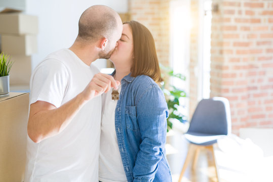 Young couple smiling very happy showing keys of new home, moving and buying new apartmet concept