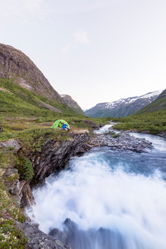 Eidsdalselva, M&macr;re og Romsdal, Norway: A male hiker at his camp on a cliff by the river.