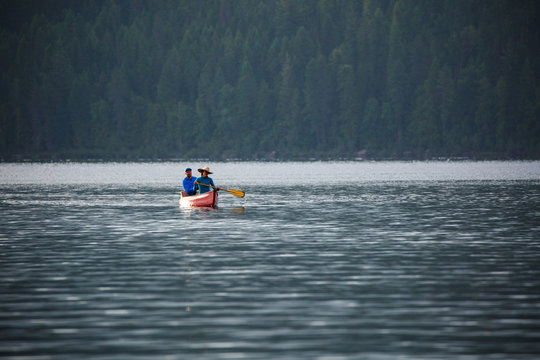 Man and woman rowing a canoe in Priest Lake