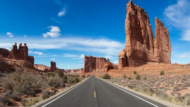 Beautiful Landscape view of a Scenic road in the red rock canyons during a vibrant sunny day. Taken in Arches National Park, located near Moab, Utah, United States. Still Image Continuous Animation