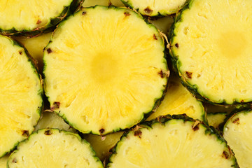 Pineapple juicy yellow slices background. Top view.