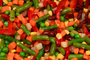 Sliced vegetables, corn, beans, peas, carrots, sweet peppers background.