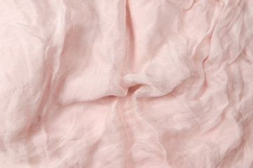 Soft smooth pink silk fabric background. Fabric texture.