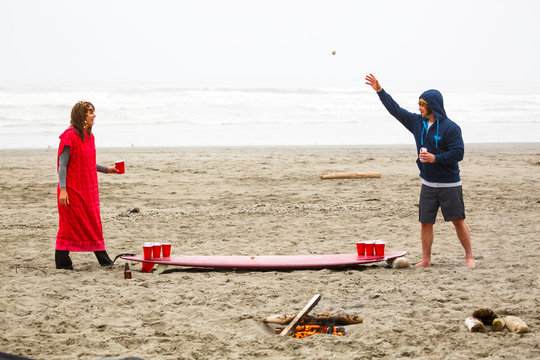 A man and woman play surfboard beer pong on a beach near Kalaloch campground in the Olympic National Park in Washington State. Not having a ping pong ball, a ball of twine and driftwood and a small dead crab were used as a substitute.