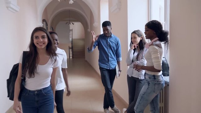 African and caucasian girls saying bye to friends in college