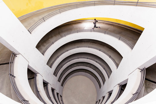 Airport car park, Stuttgart, Baden-W&cedil;rttemberg, Germany: A male runner running through a car park.