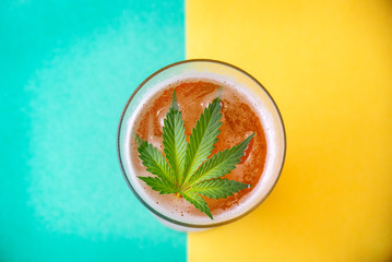 Detail of cold glass of beer with cannabis leaf