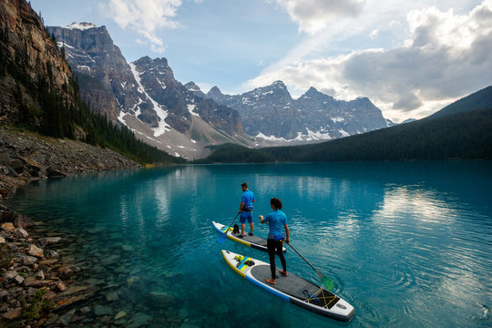 A couple stand up paddle board at Moraine Lake in Banff National Park in Canada.