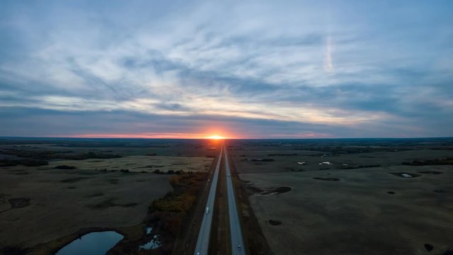 Cinemagraph of an Aerial view of the Highway in the Prairies during a vibrant cloudy sunset. Taken East of Edmonton, Alberta, Canada. Still Image Continuous Animation