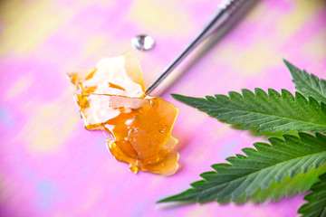 Dab tool with cannabis concentrate aka shatter and marijuana leaf,