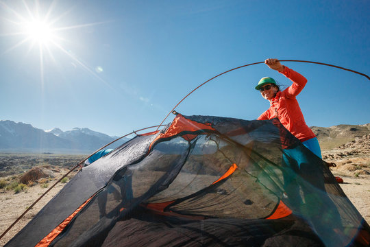 Two women set up a tent while camping during a windy spring day at the Alabama Hills near Lone Pine, California.